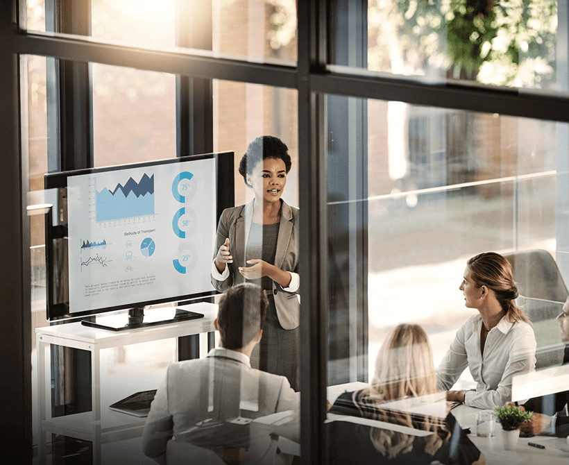 Businesswoman presenting data on a screen during a meeting.